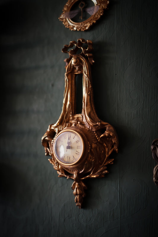 Antiklook goldene Wanduhr mit verziertem Schleifenmotiv