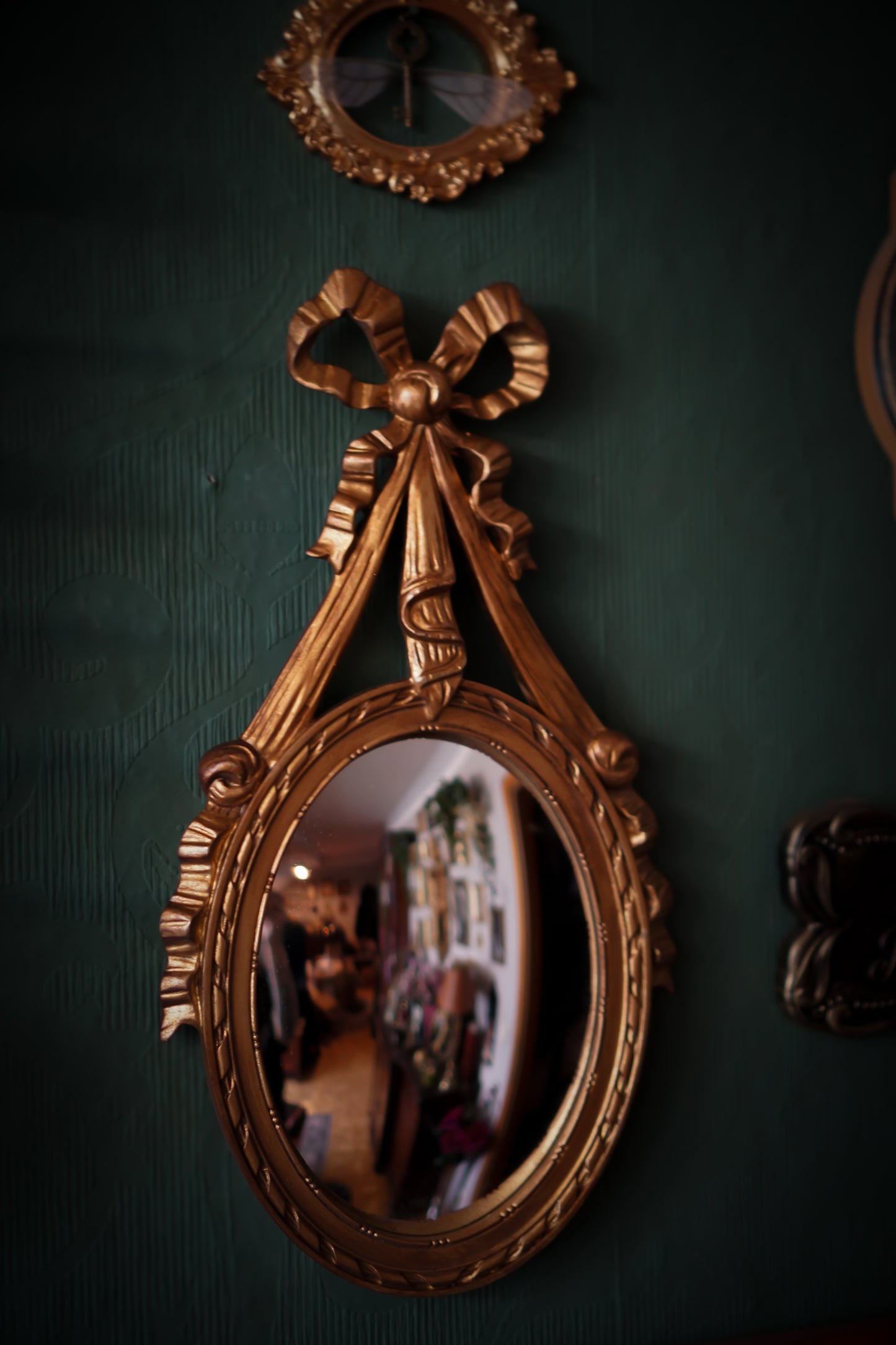 Wandspiegel mit gewölbtem Spiegelglas, Gold, verziert mit Schleifenband
